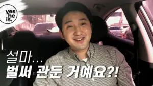 Man smiling in a car, with text in Korean asking if everything is okay, showcasing a friendly and casual mood.