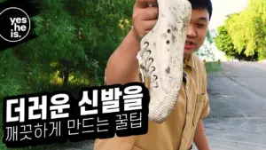 Person holding a dirty shoe outdoors, promoting a cleaning solution with Korean text and greenery in the background.