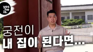 Young man speaking in front of a traditional Korean building, discussing homes and culture in a vibrant outdoor setting.