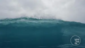 A dramatic ocean wave crashing under a cloudy sky, capturing the power and beauty of nature.