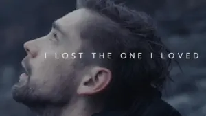 Man with a distressed expression gazing upward, with emotional text overlay about loss in the background.