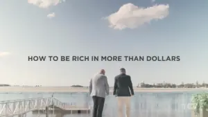 Two men walking by a serene lake under a clear sky, with text about wealth beyond money.