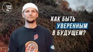 A confident man in a stylish outfit poses outdoors with a motivational message in Russian about future assurance.