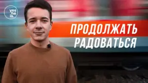 A young man smiles confidently in front of a colorful background with the text "Продолжать радоваться."