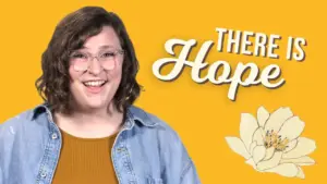 Smiling woman against a yellow background, with the text "There Is Hope" and a white flower illustration.