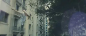 A dancer leaps gracefully between urban buildings, showcasing agility and expression against a backdrop of modern architecture.