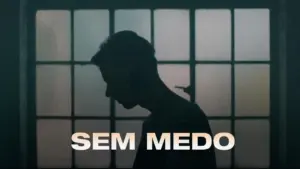 Silhouette of a person in front of a large window, with the text "SEM MEDO" prominently displayed below.