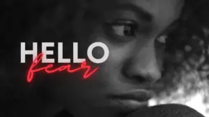 Close-up of a pensive woman with curly hair, featuring the bold text "Hello" and "Fear" in contrasting colors.