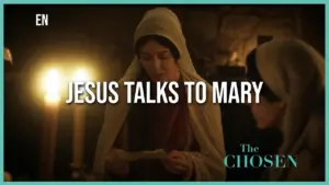 Scene from "The Chosen" featuring Jesus speaking to Mary in a dimly lit setting with candles, highlighting their interaction.