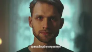 Close-up of a young man with a serious expression, illuminated by soft light in a dimly lit background.