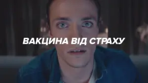 A young man with intense eyes gazes forward, with bold text overlay in Ukrainian reading "Vaccine Against Fear."