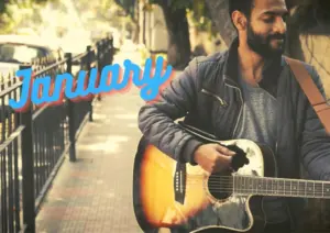 Man playing guitar on a city street with vibrant text reading "January" in the background, capturing a lively atmosphere.