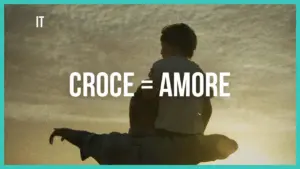 Silhouette of a parent carrying a child against a sunset, with the text "CROCE = AMORE" prominently displayed.