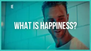 Man smiling with text overlay, "What is Happiness?" in bright colors, conveying a cheerful and uplifting mood.