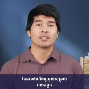 A man speaking confidently in front of a blue background, discussing important topics in a casual setting.