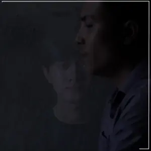 Two men in a dark setting, with one appearing as a ghostly reflection of the other, creating a mysterious atmosphere.