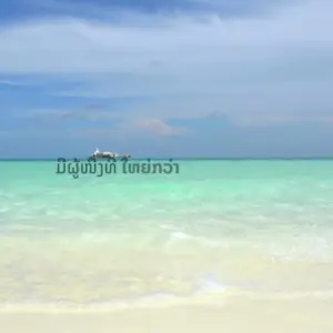 Tropical beach scene with clear turquoise water, soft white sand, and a distant boat under a blue sky.