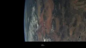 Earth's surface from space, showing vibrant land and cloud patterns against the deep blue of the atmosphere.