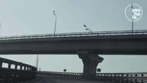 View of a modern highway overpass with streetlights against a clear sky, illustrating urban infrastructure development.