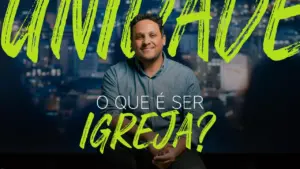 Smiling man in a blue shirt sits against a city skyline backdrop, with bold green text asking, "What does it mean to be a church?"