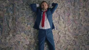 Man in a suit relaxing on a floor covered with cash, exuding confidence and success.