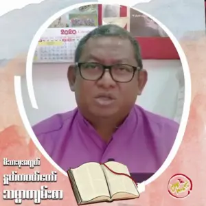 A man in a purple shirt speaking, with a book graphic and calendar in the background, conveying a message.