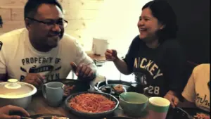 Happy friends enjoying a meal together, sharing laughter and delicious food at a cozy dining table.