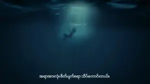 A person swimming underwater, surrounded by dark blue water, with light illuminating above.