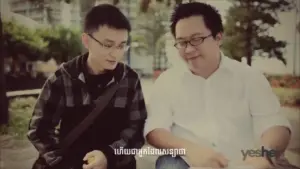 Two men collaborating outdoors, discussing ideas with notebooks in hand, surrounded by greenery and a bright atmosphere.