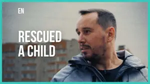 Man in a gray jacket looks thoughtfully, reflecting on an experience of rescuing a child.