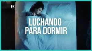 A woman struggles to sleep in a dimly lit room, under soft blankets, with the text "Luchando para dormir" above her.