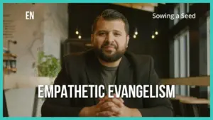 Man in a black blazer sitting at a table, promoting empathetic evangelism in a modern café setting.