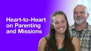 Smiling couple discussing parenting and missions against a vibrant purple background. Engaging and heartfelt conversation.