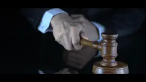 A close-up of a hand gripping a gavel, symbolizing justice and decision-making in a courtroom setting.