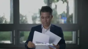 Man in a suit reviewing documents, looking thoughtful, with a bright, modern office background.