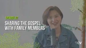 Smiling woman speaking into a microphone about sharing the gospel with family members in a bright, inviting setting.