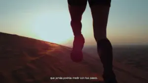 Person running on a sandy dune at sunset, highlighting determination and outdoor fitness exploration.