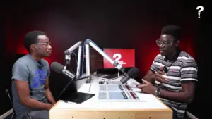 Two men discussing at a radio station studio with microphones and control panels, highlighting a talk show setting.