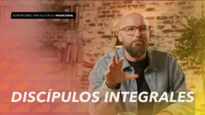 Man with glasses and beard gestures passionately in a modern setting, emphasizing the concept of "integral discipleship."