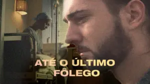 A dramatic scene featuring a man contemplating life in a hospital, with the title "Até o Último Fôlego" prominently displayed.