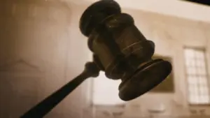 Close-up of a judge's gavel, symbolizing legal authority and courtroom proceedings, with a blurred background.