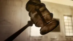 Close-up of a gavel in motion, symbolizing justice and legal proceedings in a courtroom setting.