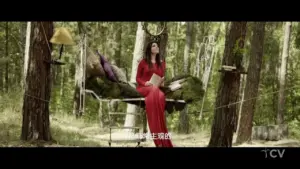 Woman in a red dress reading in a serene forest setting, surrounded by trees and artistic decor elements.