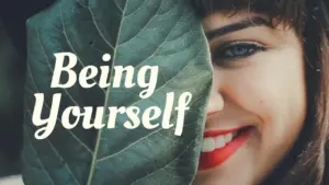 Smiling woman playfully hiding behind a leaf with the text "Being Yourself" overlaying the image.