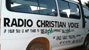 Van advertising Radio Christian Voice with bold text promoting FM station 105.8 and contact information.