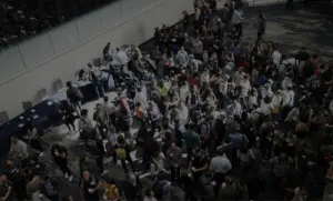 Crowd of people at a large indoor event, with attendees interacting and networking in a busy atmosphere.